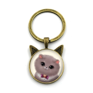 Detalle del llavero de orejas de gato en bronce con ilustración de gatito gris