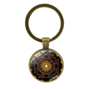 Sri Yantra mandala glass dome keychain with antique bronze alloy pendant on white background