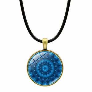 Detailed view of blue mandala pattern glass pendant with bronze metal base on black cord