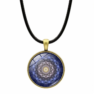 Close-up of mandala geometric pattern glass pendant on bronze frame necklace