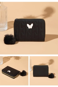 Detail of black wave-patterned short wallet with butterfly charm and plush pompom decoration