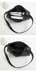 Internal view of black lychee grain bag showing capacity with sunglasses and phone
