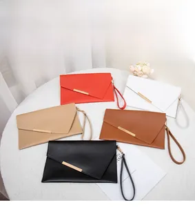 Dettaglio di cinque colori di pochette a busta con fibbia in metallo dorato e cinturino
