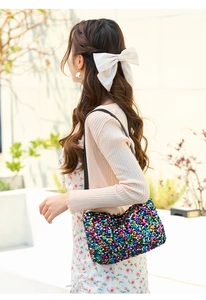 Close-up of vibrant multi-color sequin shoulder bag on model for summer fashion style