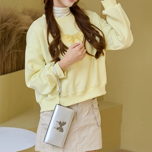 Silver long butterfly clutch wallet with metallic finish and wristlet held by model