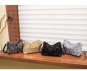 Detailed row of sequin shoulder bags in iridescent, gold, black and silver metallic colors