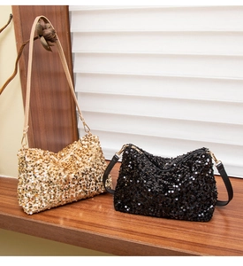 Close-up of sequined baguette shoulder bags in champagne gold and black with metallic finish