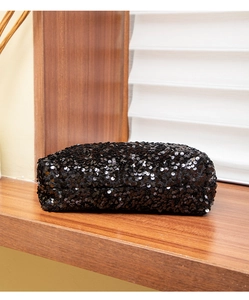 Close-up of elegant black sequined clutch bag on a display shelf for evening events