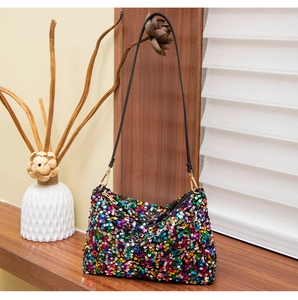 Detail of colorful sequins on a baguette bag with black strap and golden hooks