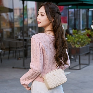 Women's cream quilted crossbody camera bag with metal butterfly clasp and wide strap