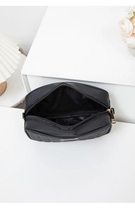 Detail view of black quilted crossbody bag showing smooth zipper and spacious interior