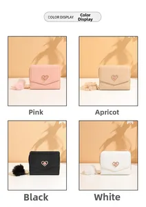 Detail view of compact wallets in four colors featuring heart hardware and plush charms