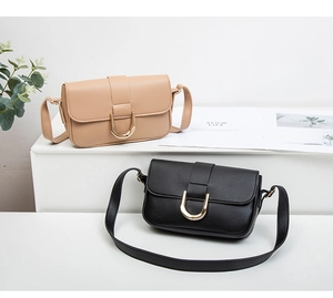 Detail of chic small crossbody bags in black and beige with elegant gold U-shaped metal buckles
