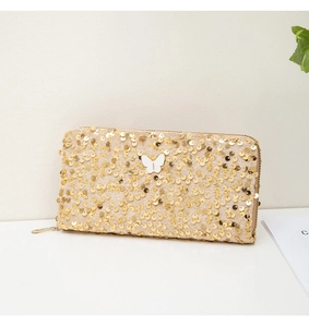 Close-up of champagne sequin long clutch wallet featuring a white butterfly ornament