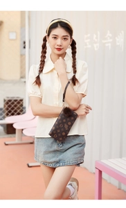 Detailed view of dark brown long wallet with vintage print and plush pompom accessory