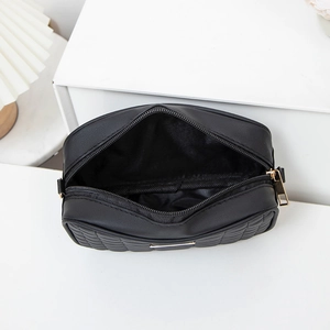 Quilted black crossbody camera bag with gold zipper and spacious inner compartment