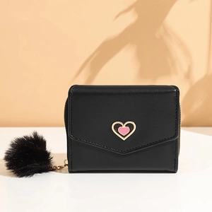 Stylish black short wallet for women with a gold heart detail and soft pom-pom charm