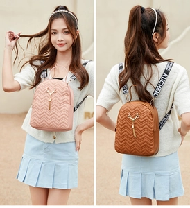 Detail of pink and brown mini backpacks with quilted texture and gold deer head charms