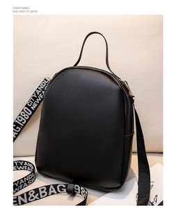 Detail of black pebbled faux leather mini backpack with patterned letter webbing strap