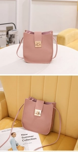 Détail du sac rose clair en similicuir grainé avec fermoir rotatif doré et bandoulière