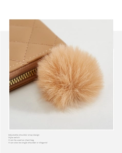 Détail du sac matelassé kaki avec fermeture éclair dorée et pompon décoratif doux