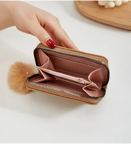 Détail du petit portefeuille matelassé marron avec doublure rose et pompon