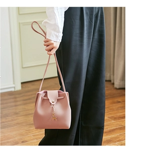 Roze crossbodytas met nappa-textuur en een verfijnde gouden hanger in de vorm van een hert