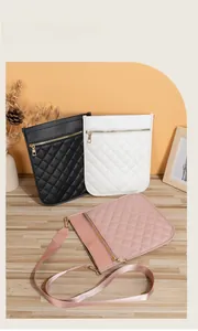 Close-up of quilted pattern crossbody bags in black, white, and pink with gold zippers