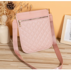 Detailed close-up of a pink quilted crossbody phone bag with wide strap and gold zipper