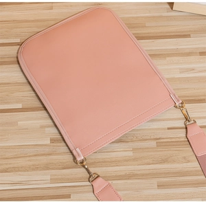 Detail of pink quilted crossbody phone bag with gold hardware and fine leather texture