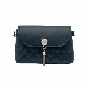 Chic black quilted crossbody bag with a gold cat-head clasp and chain tassel detail