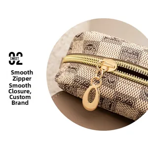 Détail de la fermeture éclair dorée et du motif à carreaux sur le sac à bandoulière