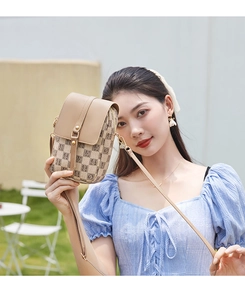 Détail d'un petit sac de téléphone vertical beige avec motif H et rabat en cuir porté