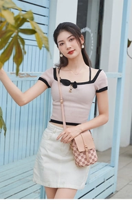Détail du petit sac bandoulière rose avec monogramme vintage et boucle en métal doré