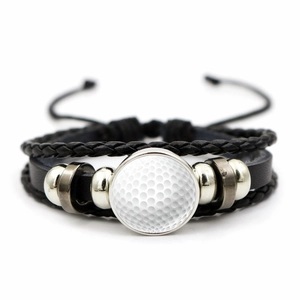 Dettaglio macro del bracciale in pelle multistrato con ciondolo a tema pallina da golf