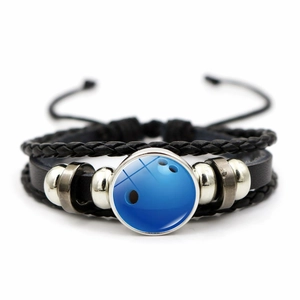 Dettaglio di un bracciale multistrato in pelle con ciondolo in vetro palla da bowling blu