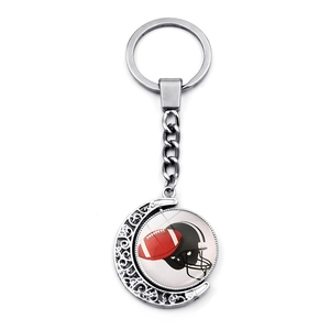 Rotating sports keychain with American football and helmet motif in moon-shaped frame