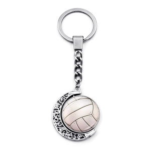 Detail of silver rotating volleyball keychain with crescent moon filigree pattern