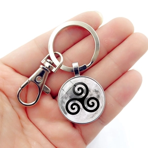 Detailed shot of moon pendant with triskelion symbol on a lobster clasp keychain