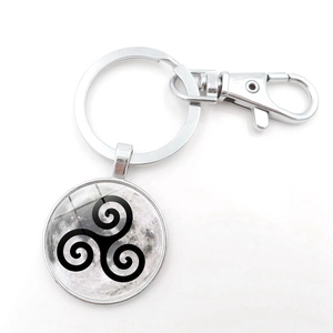 Silver metal keychain featuring a triskelion symbol on a realistic moon glass pendant
