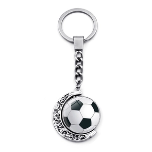 Spinning silver metal soccer ball keychain with a crescent moon frame on a white background