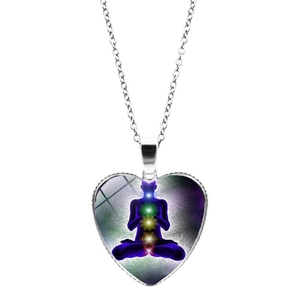 Détail d'un pendentif coeur argenté avec un design coloré de chakra et méditation yoga