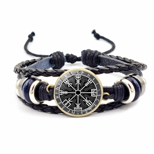 Makro-Detail von Wikinger Vegvisir Kompass und Runen auf geflochtenem Lederarmband