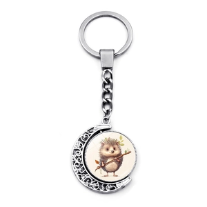 Detail of silver rotating crescent moon keychain featuring a cute hedgehog illustration