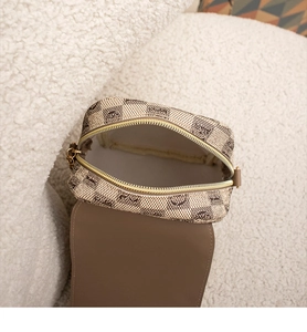 Détail de la doublure et du zip doré d'un petit sac à bandoulière au motif damier beige