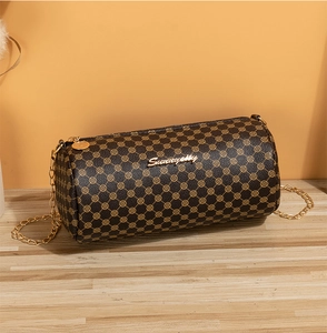 Macro detail of retro patterned cylinder bag featuring golden Sunny City metal logo