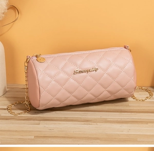 Detailed view of pink quilted cylinder bag with gold chain strap and metal logo