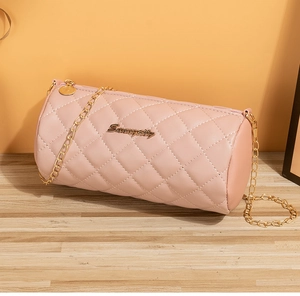 Detailed view of pink quilted cylindrical bag with golden chain and metallic logo
