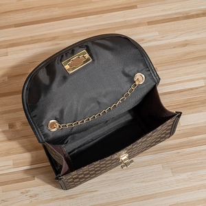 Brown quilted chain shoulder bag with gold hardware and vintage pattern on wood floor