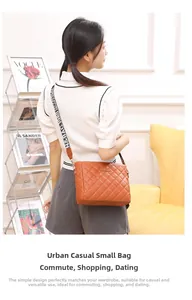 Close-up of orange-brown quilted crossbody bag with stylish contrast lettered strap